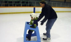Father and son using skate helper skating aid